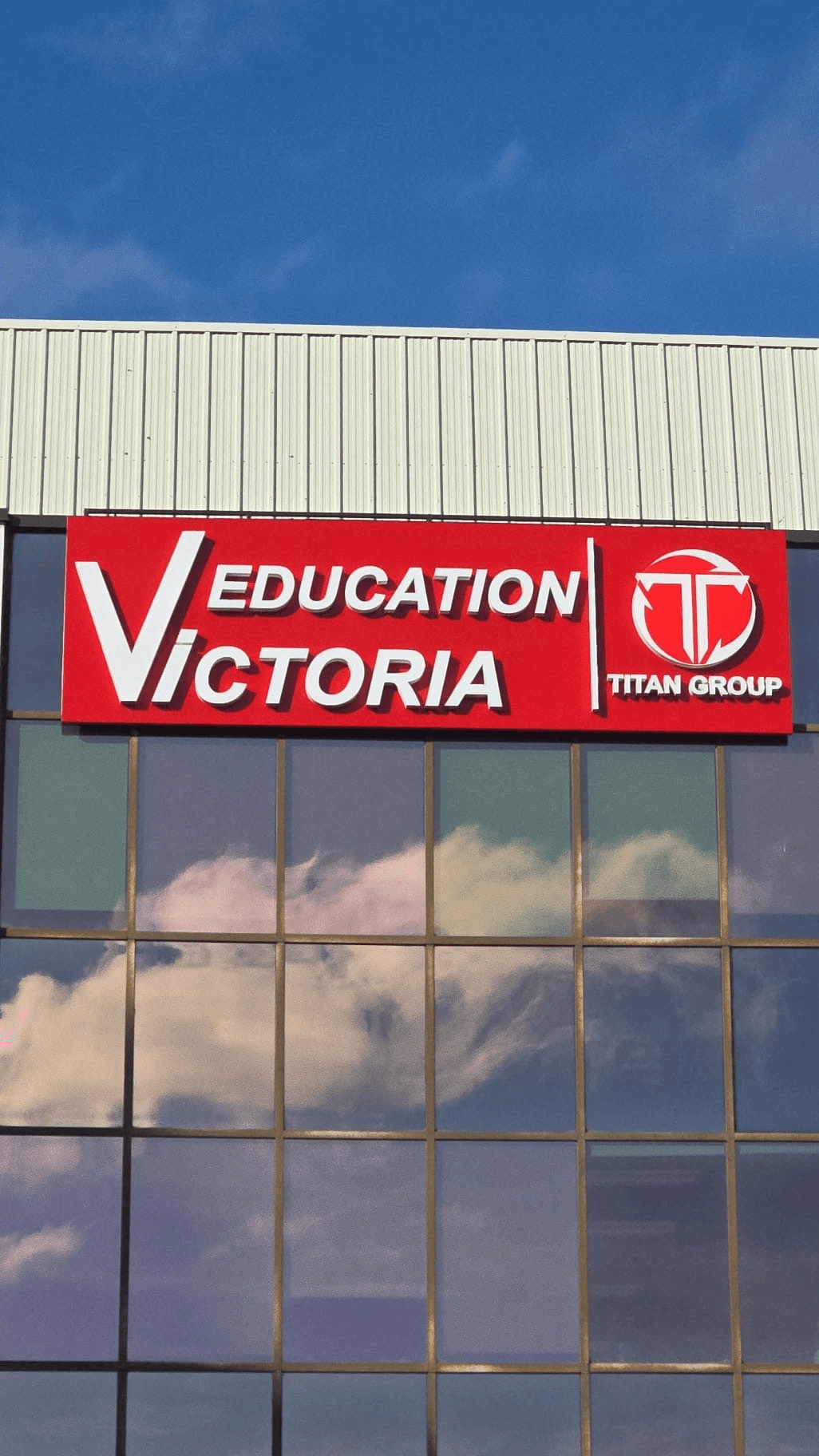 Completed illuminated Victoria Education sign mounted on the office tower