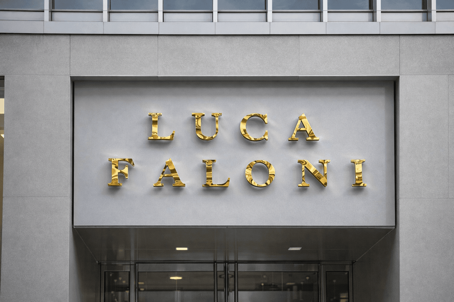Luca Faloni polished gold dimensional letters mounted on a grey stone storefront