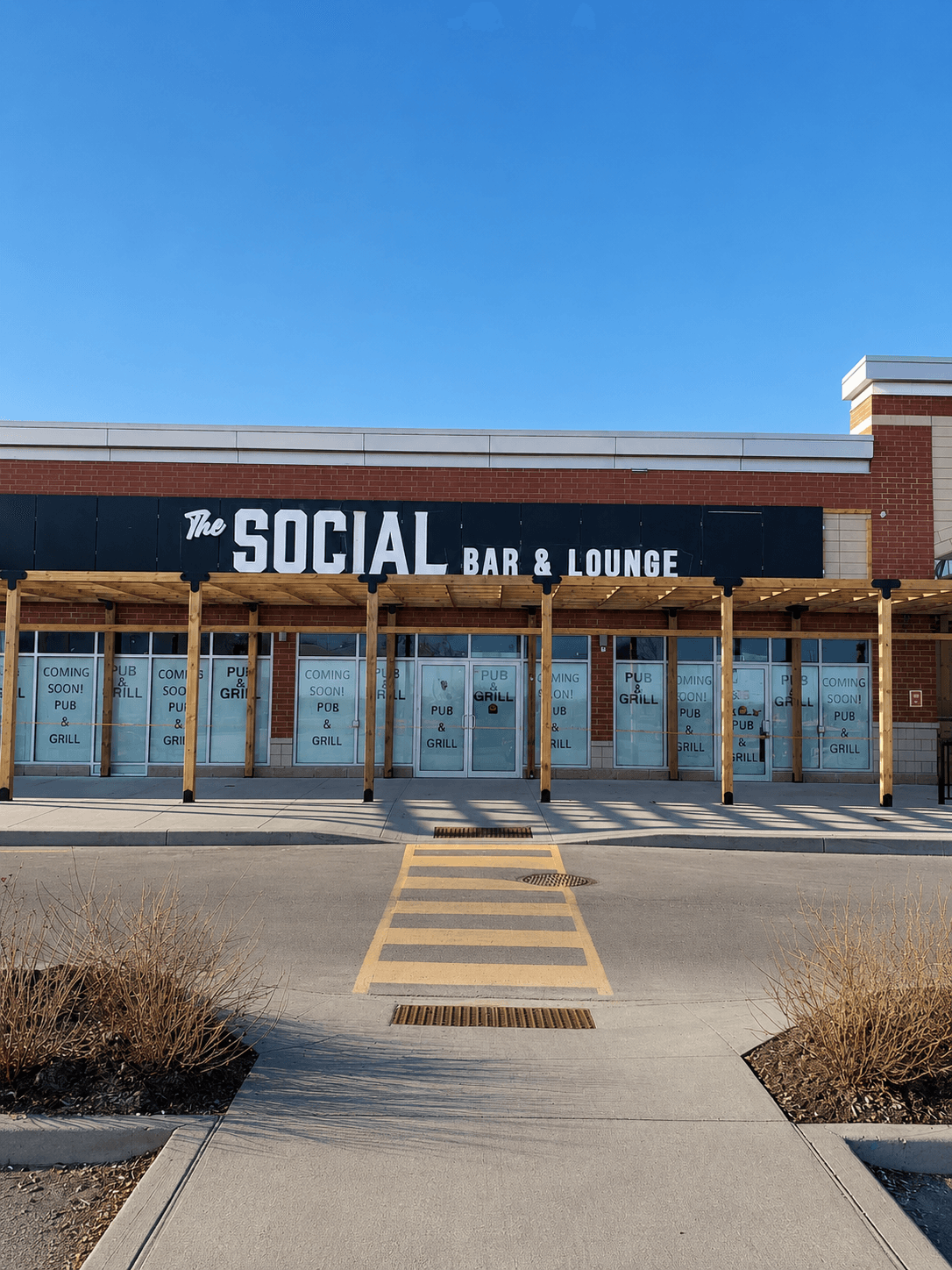 The Social Bar & Lounge storefront with channel letter signage under a wood pergola